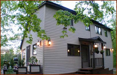 "Back" of dwelling facing driveway, and deck side wall whick looks out onto the lake.