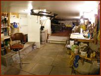Basement showing primary drive-in storage and work area, with elevated slide-in canoe and kayak storage in the distance.